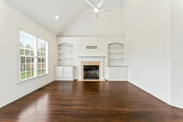 an empty room with windows and a fireplace