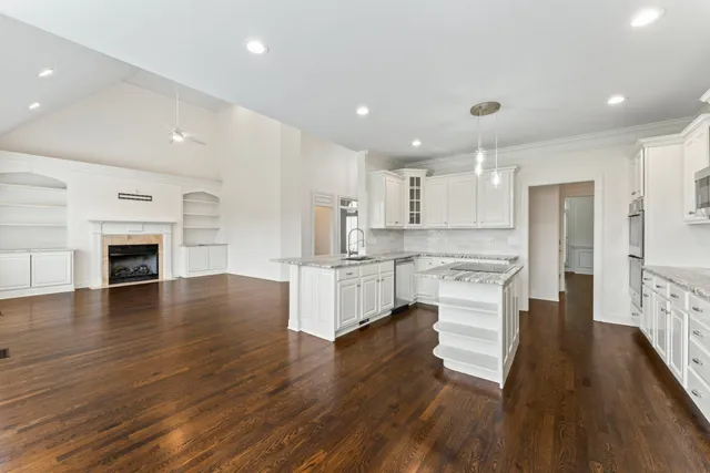 a kitchen with granite countertop a sink a counter top space and cabinets