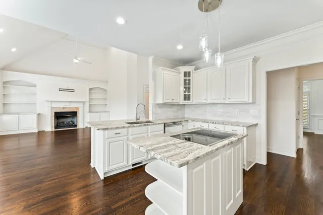 a kitchen with granite countertop a sink and a stove top oven
