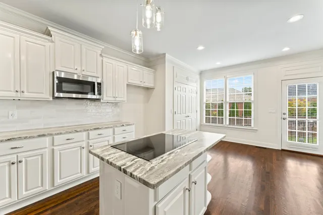 a kitchen with stainless steel appliances granite countertop a sink stove and cabinets