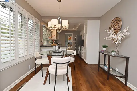 a view of a dining room with furniture a chandelier and wooden floor