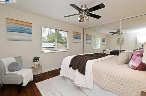 a bedroom with a large bed couch and a window