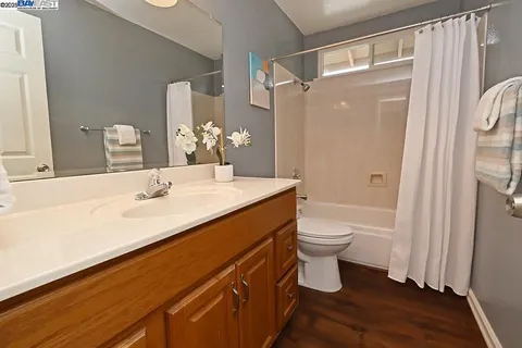 a bathroom with a double vanity sink toilet mirror and shower