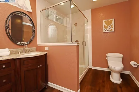 a bathroom with a toilet sink vanity and mirror