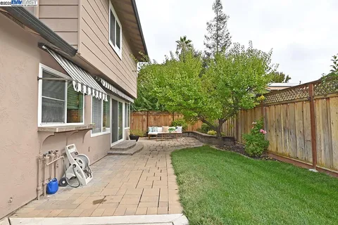 a view of a house with backyard and sitting area