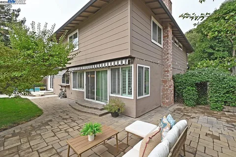 a view of a house with backyard sitting area and garden