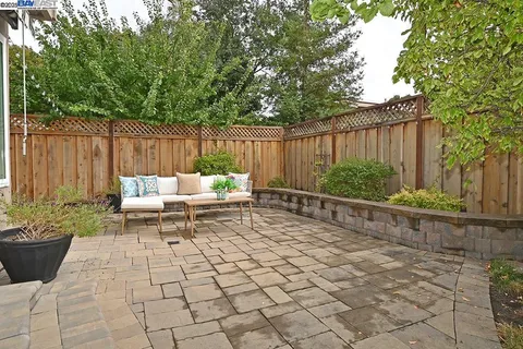 a white bench sitting in front of a wooden fence