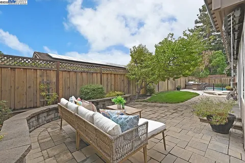 a view of a patio with table and chairs potted plants and wooden fence