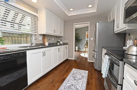 a kitchen with a sink a stove and cabinets