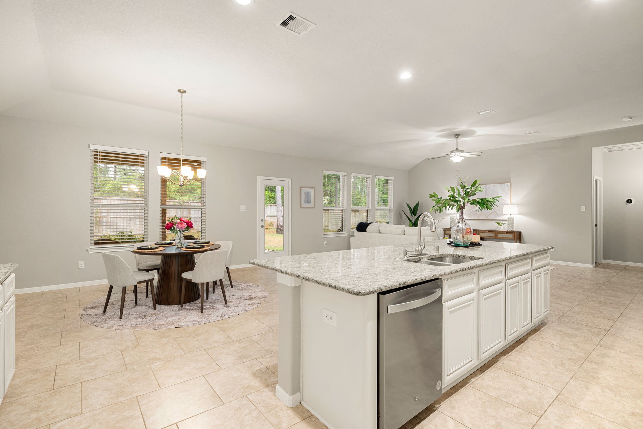 14023 Beaverhead Range Court Conroe, TX 77384 - Photo 11 of 30 Experience a truly commanding view from the heart of this open-concept home! The windows create a seamless visual connection to the outdoors, offering picturesque views of the private backyard.