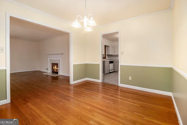 a view of a room with wooden floor and kitchen