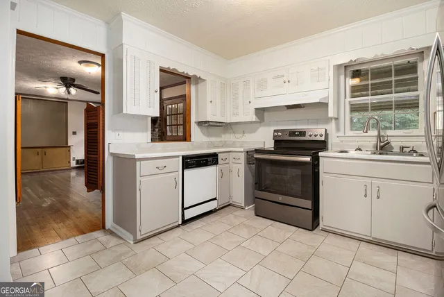 a kitchen with white cabinets and white appliances