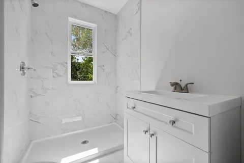 a white bath tub sitting next to a white sink