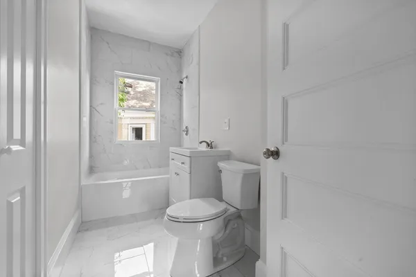 a bathroom with a toilet and a bath tub