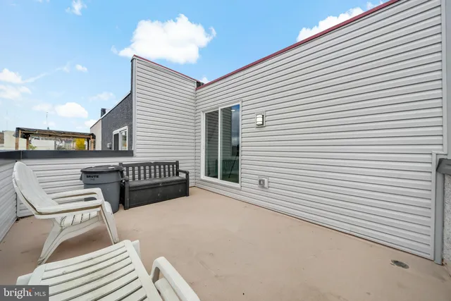 a backyard of a house with barbeque oven table and chairs