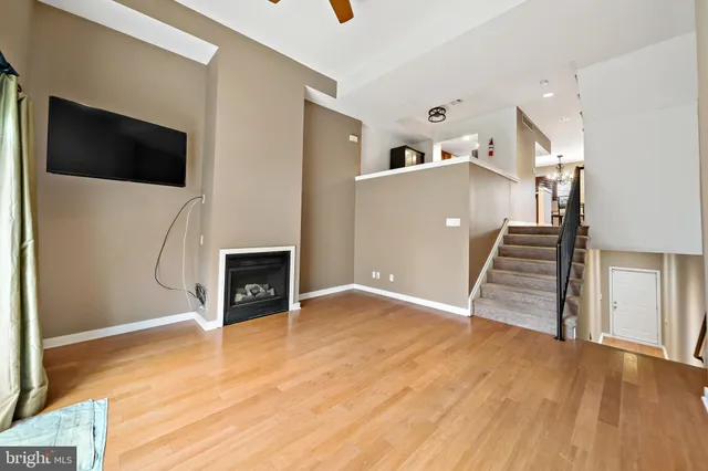 a view of a livingroom with wooden floor and staircase