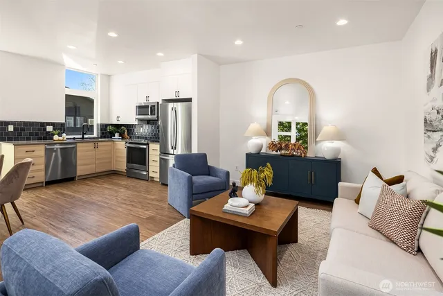 a living room with furniture kitchen view and a refrigerator