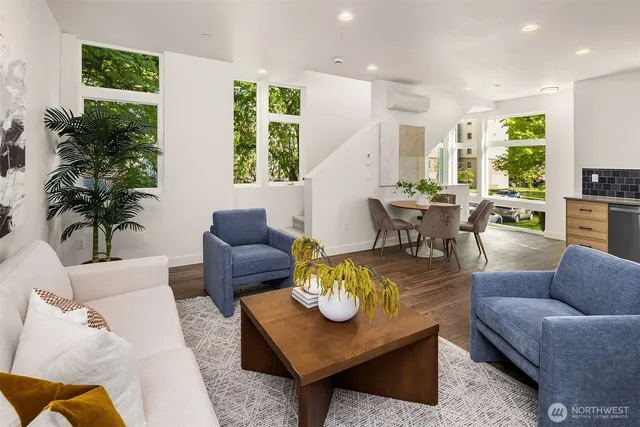 a living room with furniture potted plant and a large window