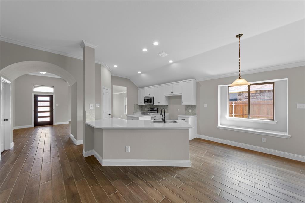 314 Pennington Road Josephine, TX 75173 - Photo 11 of 26 a view of a kitchen with kitchen island a sink wooden floor and a living room view