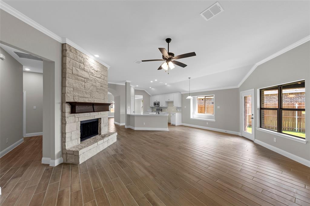 314 Pennington Road Josephine, TX 75173 - Photo 14 of 26 an empty room with wooden floor fireplace and windows