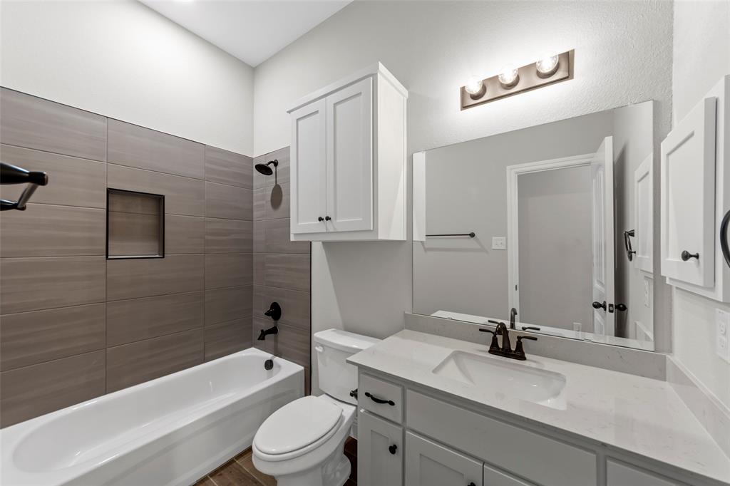 314 Pennington Road Josephine, TX 75173 - Photo 21 of 26 a bathroom with a granite countertop sink toilet a mirror and shower