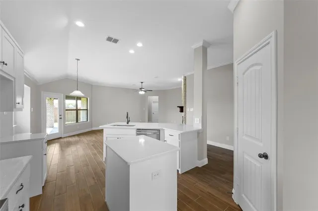 a view of a kitchen with a sink wooden floor and windows