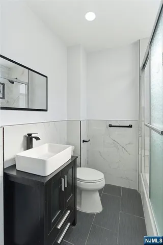 a bathroom with a sink toilet and mirror