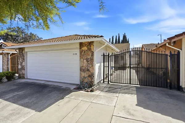 a view of a brick house with wooden fence
