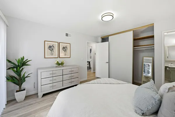 a bedroom with a bed and a potted plant