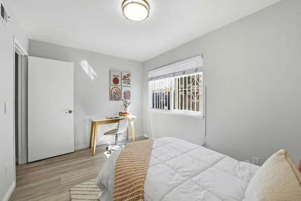 a bedroom with a bed and wooden floor