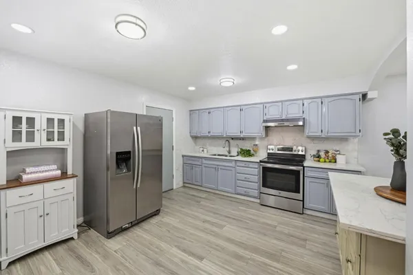 a kitchen with stainless steel appliances a refrigerator stove and sink