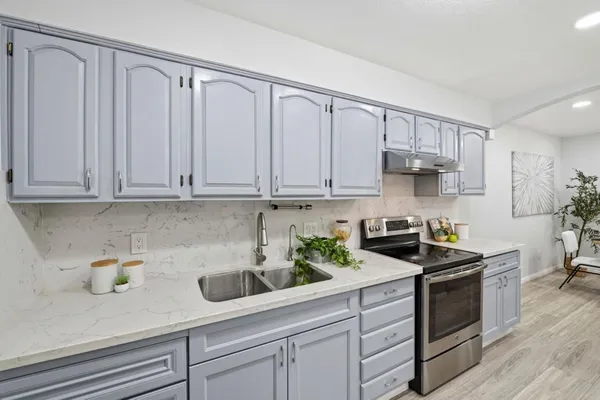 a kitchen with white cabinets and white appliances