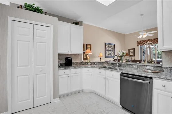 a kitchen with white cabinets and sink
