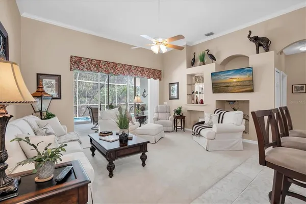 a living room with furniture ceiling fan and a large window