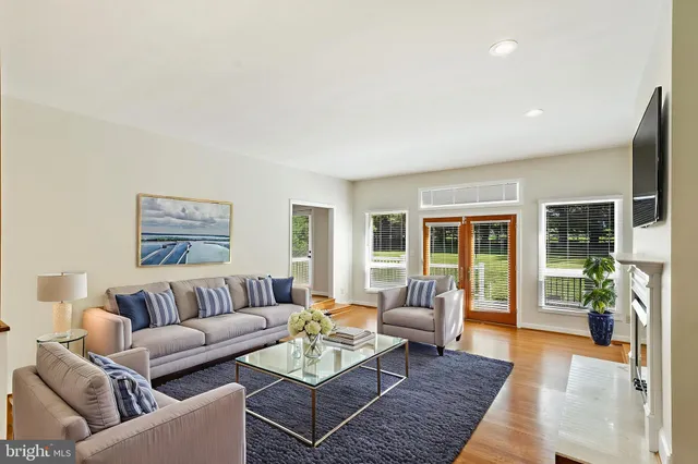 an empty room with wooden floor fireplace and windows