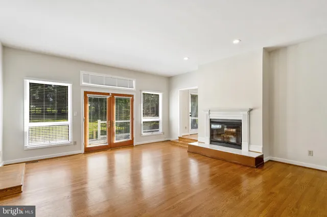 a view of empty room with wooden floor and fireplace