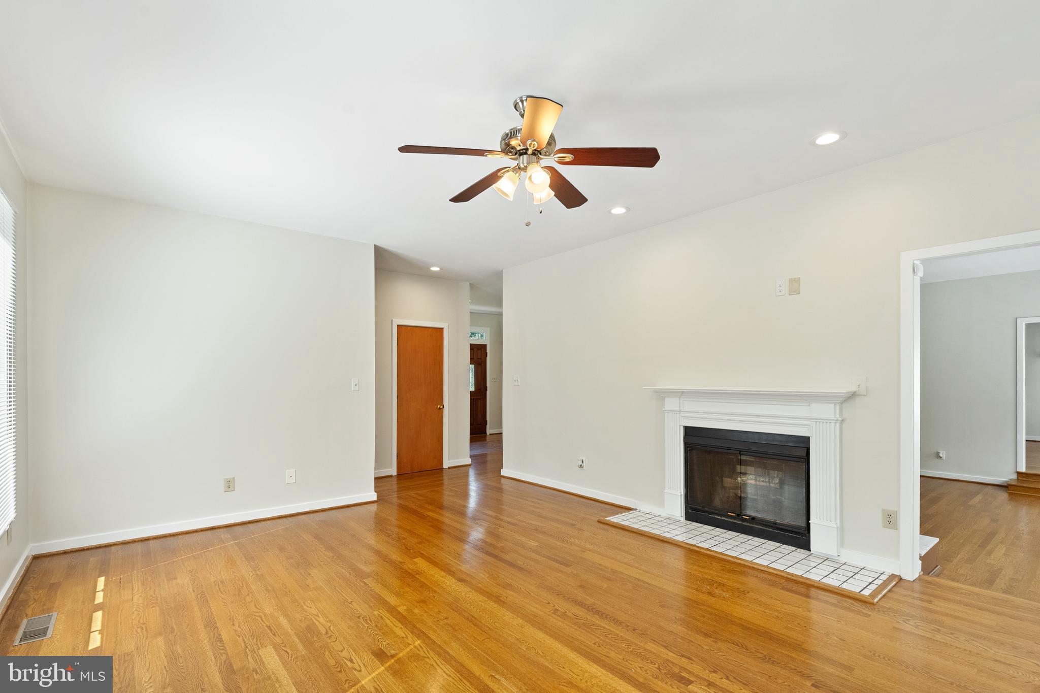 445 Springvale Road Great Falls, VA 22066 - Photo 7 of 62 a view of empty room with wooden floor and fireplace