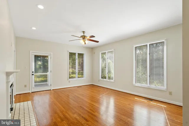 a living room with furniture a bookshelf and a window
