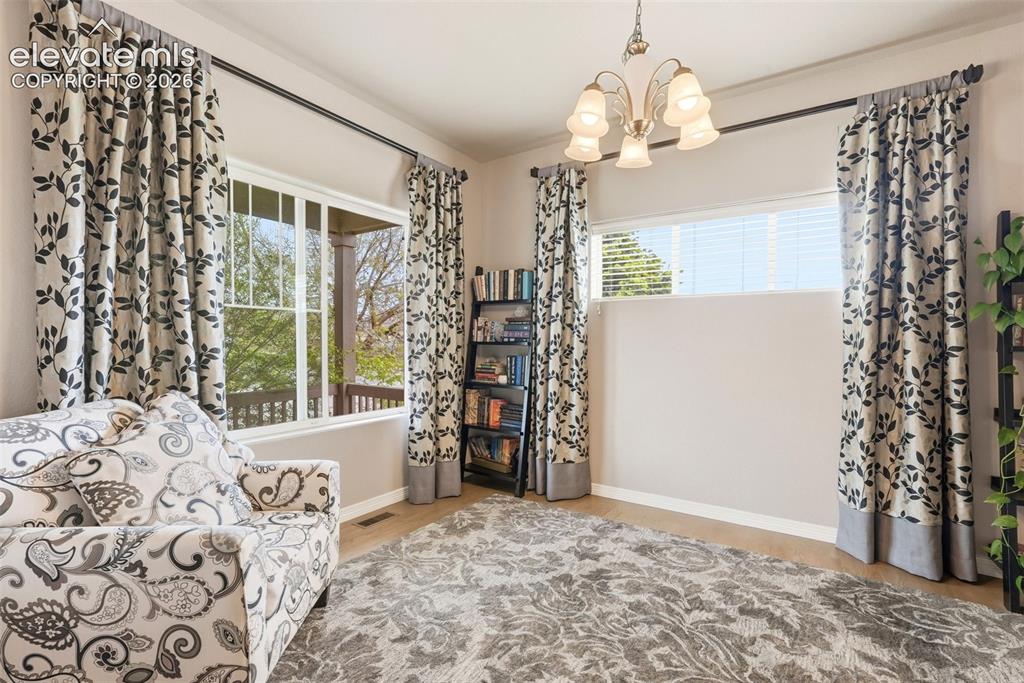 2264 Reed Grass Way Colorado Springs, CO 80915 - Photo 4 of 50 a view of a livingroom with wooden floor and a chandelier