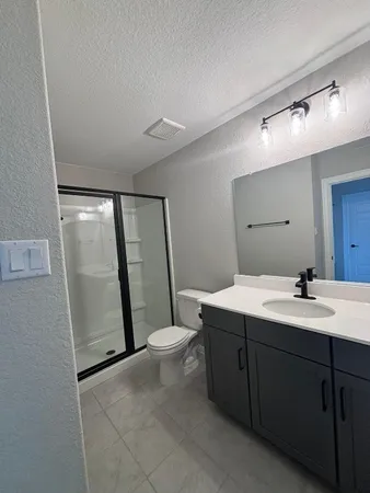 a bathroom with a sink a toilet a mirror and vanity