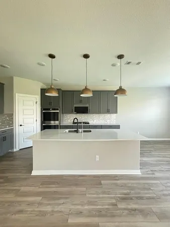 a view of kitchen and hall with wooden floor