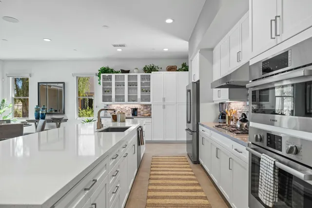 a kitchen with stainless steel appliances granite countertop a refrigerator and a sink