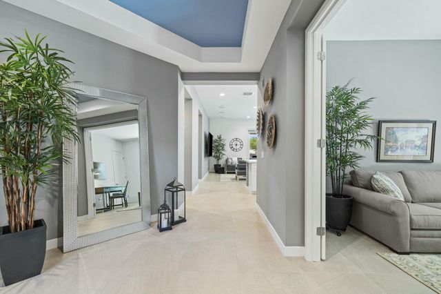 a living room with furniture a clock and a large window