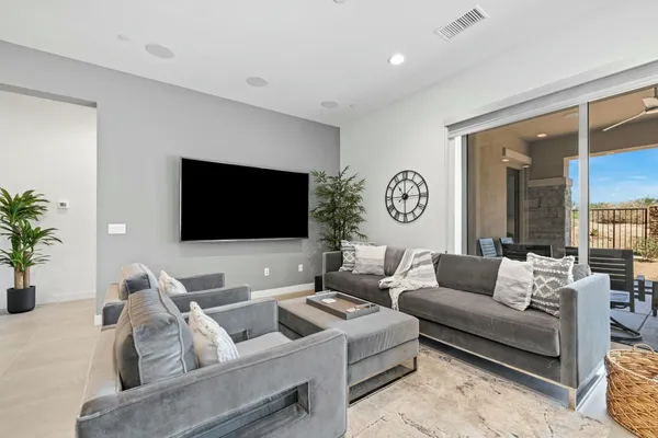 a living room with furniture wooden floor and kitchen view