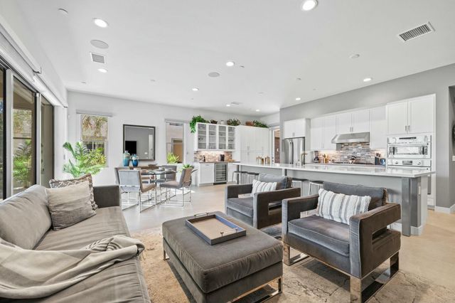 a living room with furniture a flat screen tv and a wall painting
