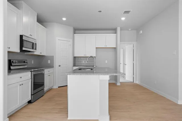 a kitchen with a sink and a stove top oven