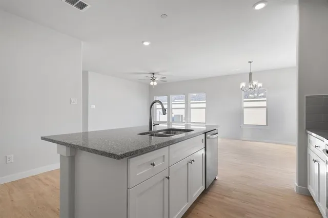 a kitchen with stainless steel appliances granite countertop a sink stove and cabinets