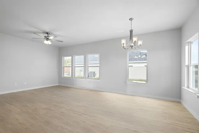 an empty room with windows and fan