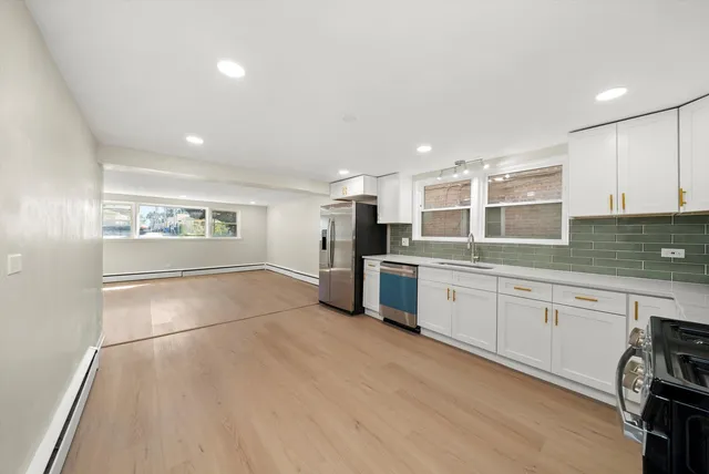 a large kitchen with a large counter top appliances and cabinets