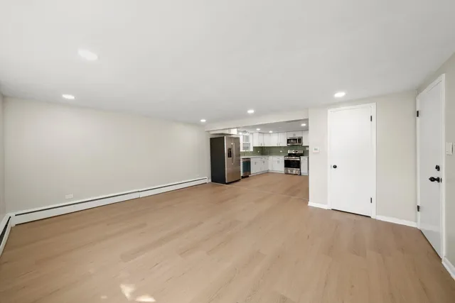 a view of empty room with kitchen